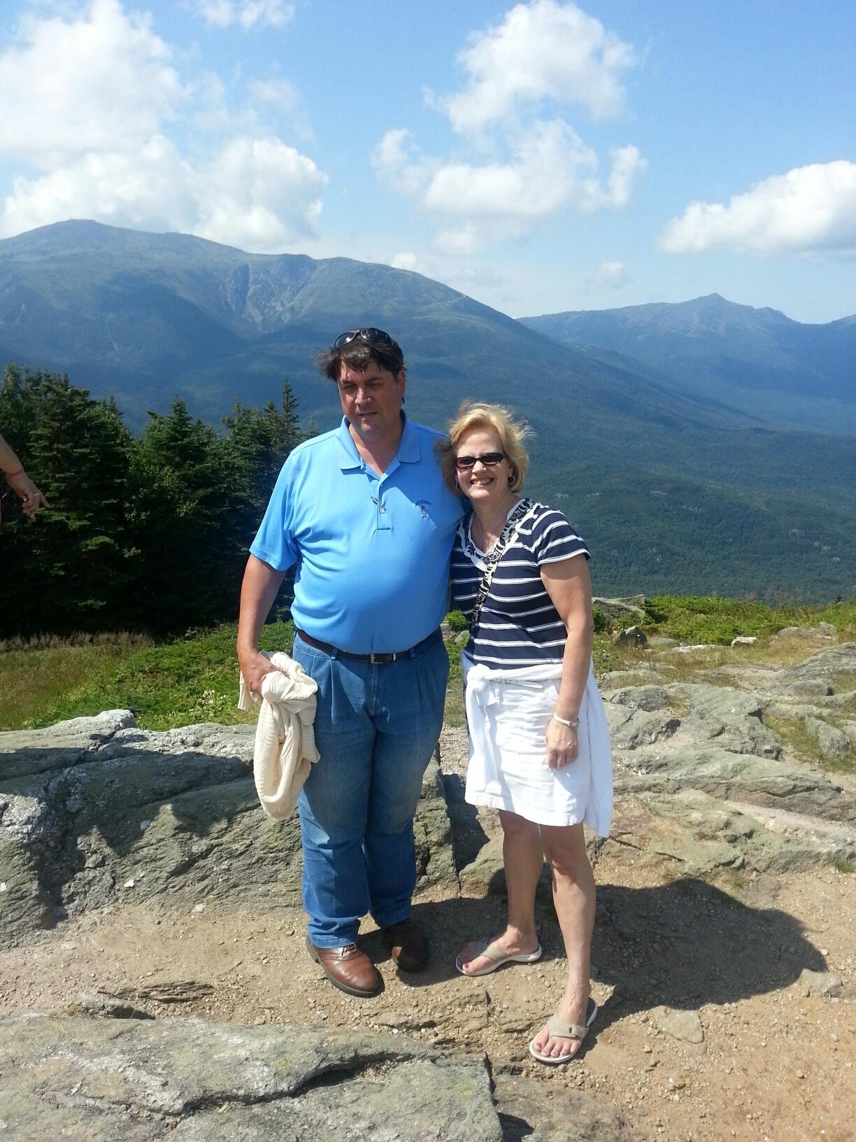 Todd and Caren standing together in the White Mountains under a bright blue sky.